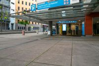 people walking in and out of a bus station with signs on the top and bottom