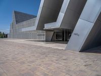 a white building with several steps and large glass panels in the facade is a mosaic that depicts a man