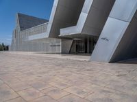 a white building with several steps and large glass panels in the facade is a mosaic that depicts a man