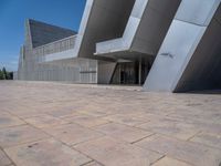 a white building with several steps and large glass panels in the facade is a mosaic that depicts a man