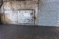 an old wooden floor with wood planks and a brick wall behind it and an open door