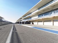 a very long road with an empty pit area on one side and a track on the other