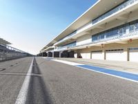 a very long road with an empty pit area on one side and a track on the other
