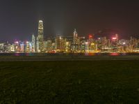 a cityscape at night as the lights of skyscrapers shine on the hills