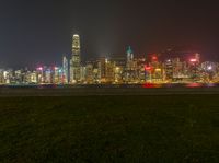 a cityscape at night as the lights of skyscrapers shine on the hills