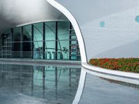 the reflection in the pool is of the building's facade, which appears as a curved, white wall