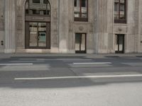 the reflection of the two people on a road in front of a tall building with a door