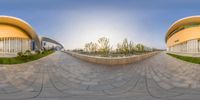 the reflection of two buildings in a fish - eye lens of a skateboarder performing a trick