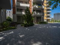 a paved brick street with red trash bins sitting in the middle and trees near to it