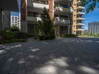 a paved brick street with red trash bins sitting in the middle and trees near to it