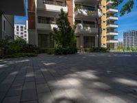 a paved brick street with red trash bins sitting in the middle and trees near to it