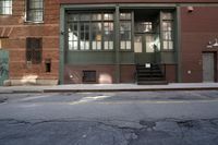 an alley way with people walking along and two cars in the street and buildings behind