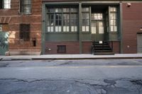 an alley way with people walking along and two cars in the street and buildings behind
