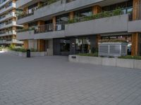 a man on a skateboard near a building with plants on the balconies