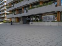 a man on a skateboard near a building with plants on the balconies