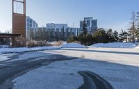 a parking lot in front of a building, covered with snow and covered in thickening snow