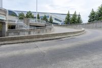 a long curved sidewalk is at the top of an outdoor walkway area with stairs leading to an office building