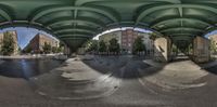 a fisheye lens with several street images in it taken at a bus stop under a bridge