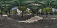 a fisheye lens panoramic view of an empty road outside with a lot of buildings in the background