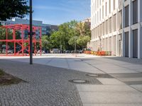 a sidewalk in front of some buildings with tall trees next to the street curb with a fire hydrant in between them