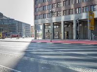 an urban road and a building, with the reflection of a woman in the car