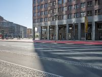 an urban road and a building, with the reflection of a woman in the car