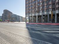 an urban road and a building, with the reflection of a woman in the car