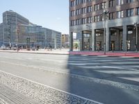 an urban road and a building, with the reflection of a woman in the car