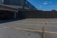 an empty parking space with yellow lines painted down the middle of it and two garages on top