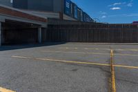 an empty parking space with yellow lines painted down the middle of it and two garages on top