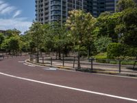 empty road with white lines on the streets of city area against cloudy blue sky on a sunny day