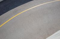 a road with a concrete wall and two metal circular ball lights on the side of the road