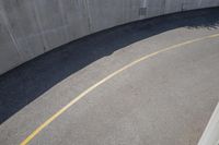 a road with a concrete wall and two metal circular ball lights on the side of the road