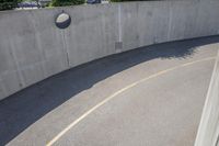 a road with a concrete wall and two metal circular ball lights on the side of the road