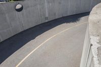 a road with a concrete wall and two metal circular ball lights on the side of the road