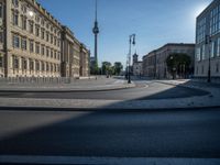 a street light next to an empty road in front of a building with a traffic light on top of it