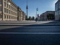 a street light next to an empty road in front of a building with a traffic light on top of it