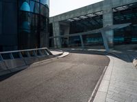 some concrete walkway next to a tall building with an opening door in the middle of the road