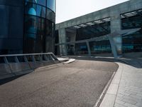 some concrete walkway next to a tall building with an opening door in the middle of the road