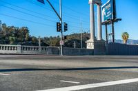 a traffic light at the intersection of an urban road and road that crosses over the freeway