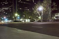 an empty city street with lights and tall buildings at night hours of the day and night