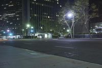 an empty city street with lights and tall buildings at night hours of the day and night