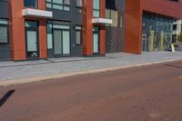 a man riding his skateboard down a paved road in front of a large building