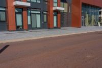 a man riding his skateboard down a paved road in front of a large building