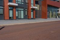 a man riding his skateboard down a paved road in front of a large building