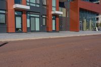 a man riding his skateboard down a paved road in front of a large building