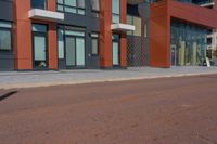 a man riding his skateboard down a paved road in front of a large building