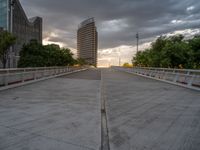 there is a large cement bridge over the road on a cloudy day with tall buildings in the background