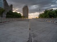 there is a large cement bridge over the road on a cloudy day with tall buildings in the background