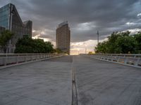 there is a large cement bridge over the road on a cloudy day with tall buildings in the background